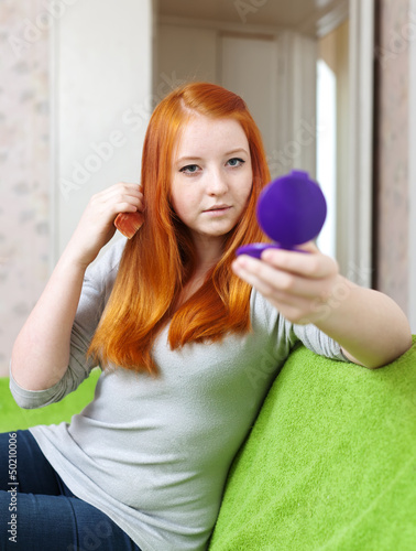 Photo: red-haired teen girl combing hair red-haired teen girl combing hair