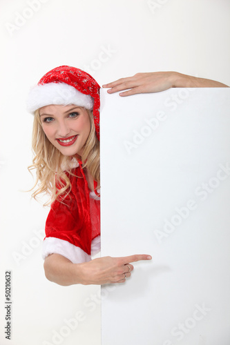 Photo: woman wearing a Santa suit and holding an advertising board woman wearing a Santa suit and holding an advertising board