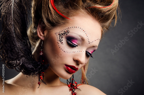 Photo: Beautiful girl with a mask and make up on gray background Beautiful girl with a mask and make up on gray background