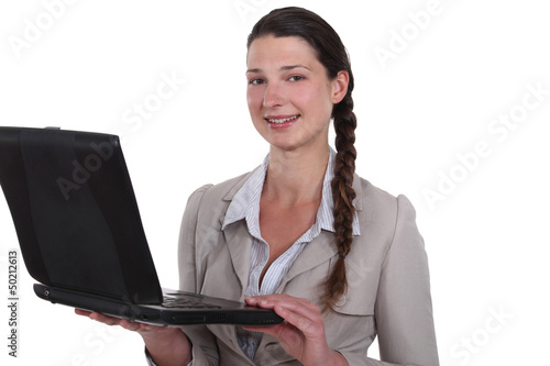 Photo: Businesswoman standing with her laptop. Businesswoman standing with her laptop.