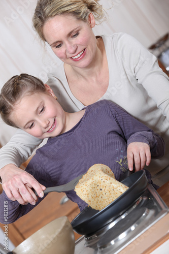 Photo: Mother and daughter cooking pancakes Mother and daughter cooking pancakes