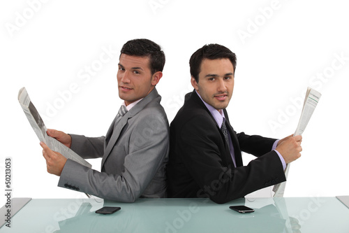 Photo: Two businessmen reading the newspaper Two businessmen reading the newspaper