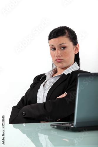 Photo: bored businesswoman looking at her laptop bored businesswoman looking at her laptop