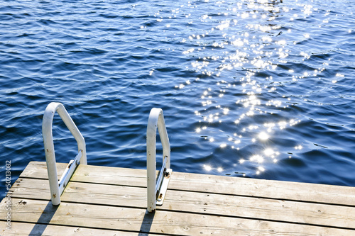 Photo: Dock on summer lake with sparkling water Dock on summer lake with sparkling water