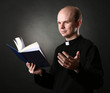 Priest with Holly Bible on black background