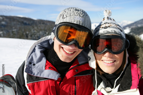 Photo: Skiing couple laying in the snow Skiing couple laying in the snow