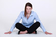 Stern businesswoman sitting cross legged