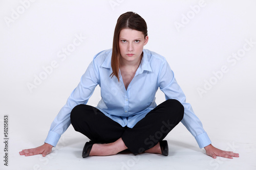 Photo: Stern businesswoman sitting cross legged Stern businesswoman sitting cross legged