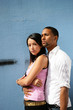 Mixed race couple stood by wall