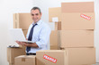 Man in suit surrounded by stacks of boxes