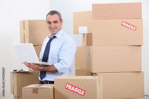 Photo: Man in suit surrounded by stacks of boxes Man in suit surrounded by stacks of boxes