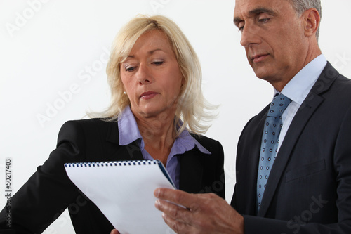 Photo: Mature business couple looking at a document Mature business couple looking at a document