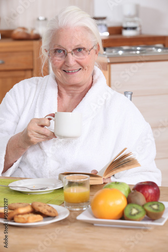 Photo: Senior woman having a relaxed breakfast Senior woman having a relaxed breakfast