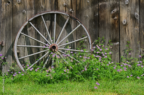 Photo: Wooden Wheel against Barn Wall Wooden Wheel against Barn Wall
