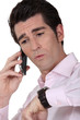 Man on the telephone checking watch