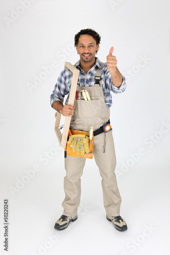 Photo: Male woodworker carrying frame Male woodworker carrying frame