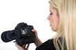 Junge Fotografin blickt auf Kamera Display