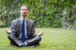 Young businessman meditating in the garden