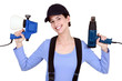 Woman holding paint sprayer and heat gun
