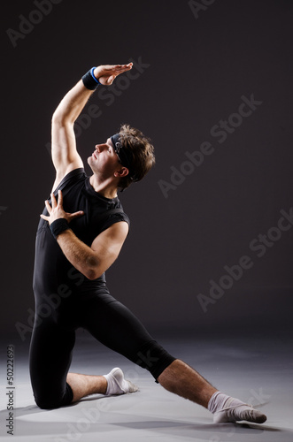 Photo: Dancer dancing dances in dark studio Dancer dancing dances in dark studio