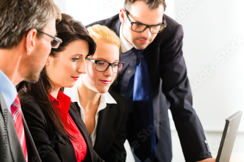 Photo: Businesspeople looking at laptop screen Businesspeople looking at laptop screen