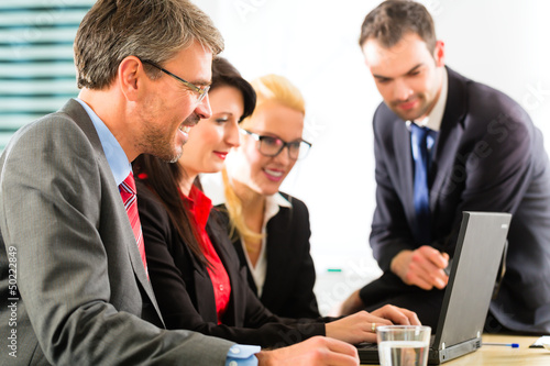 Photo: Businesspeople looking at laptop screen Businesspeople looking at laptop screen