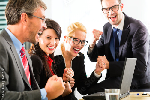 Photo: Business people looking at laptop with success Business people looking at laptop with success