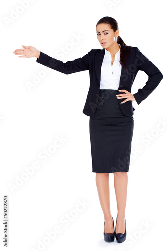 Photo: Business woman standing and pointing at copy space Business woman standing and pointing at copy space