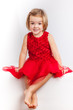 Foto: Beautiful little girl in red dresses Beautiful little girl in red dresses