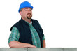Confident mason proudly stood by wall
