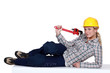 Attractive blond plumber laying with wrench