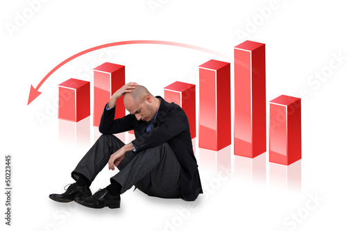 Photo: Depressed businessman with a downward chart Depressed businessman with a downward chart