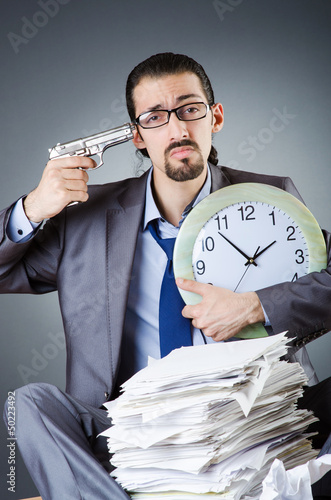 Photo: Man with clock and pile of papers Man with clock and pile of papers