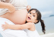 Girl loving her pregnant mother