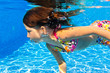Underwater child in swimming pool,  girl swims and having fun