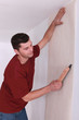 man wallpapering