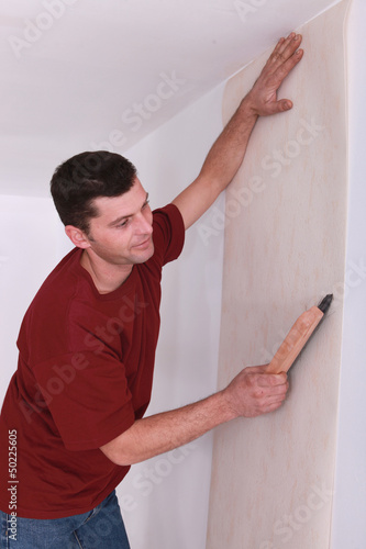 Photo: man wallpapering man wallpapering