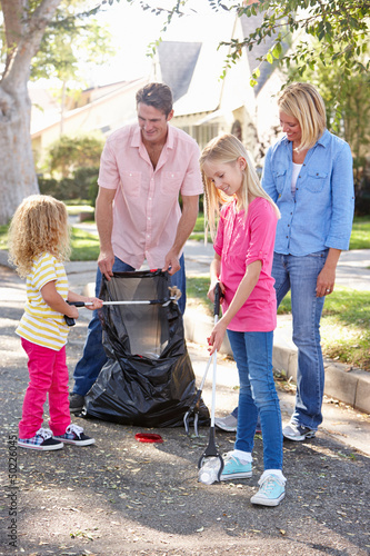 Photo: Family Picking Up Litter In Suburban Street Family Picking Up Litter In Suburban Street