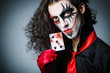Evil clown with cards in dark room
