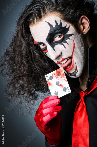 Photo: Evil clown with cards in dark room Evil clown with cards in dark room