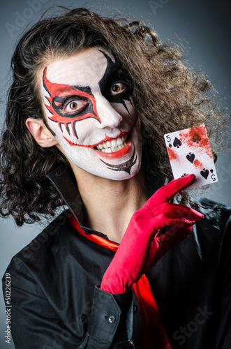Photo: Evil clown with cards in dark room Evil clown with cards in dark room