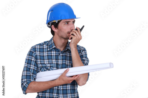 Photo: Engineer with plans and a walkie talkie Engineer with plans and a walkie talkie