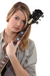 Blond teenage girl posing with guitar