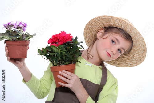Photo: 9 years old girl dressed in horticulturist taking flower pots 9 years old girl dressed in horticulturist taking flower pots