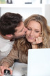 Husband kisses wife on the cheek.
