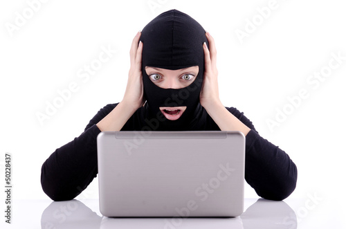 Photo: Hacker with computer wearing balaclava Hacker with computer wearing balaclava