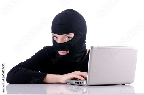 Photo: Hacker with computer wearing balaclava Hacker with computer wearing balaclava