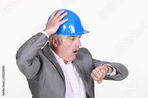 Photo: mature architect consulting his watch mature architect consulting his watch