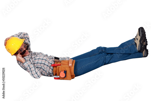 Photo: Female builder in sunglasses laying down Female builder in sunglasses laying down