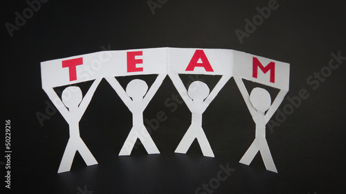 Photo: Paper silhouettes holding a Team sign Paper silhouettes holding a Team sign